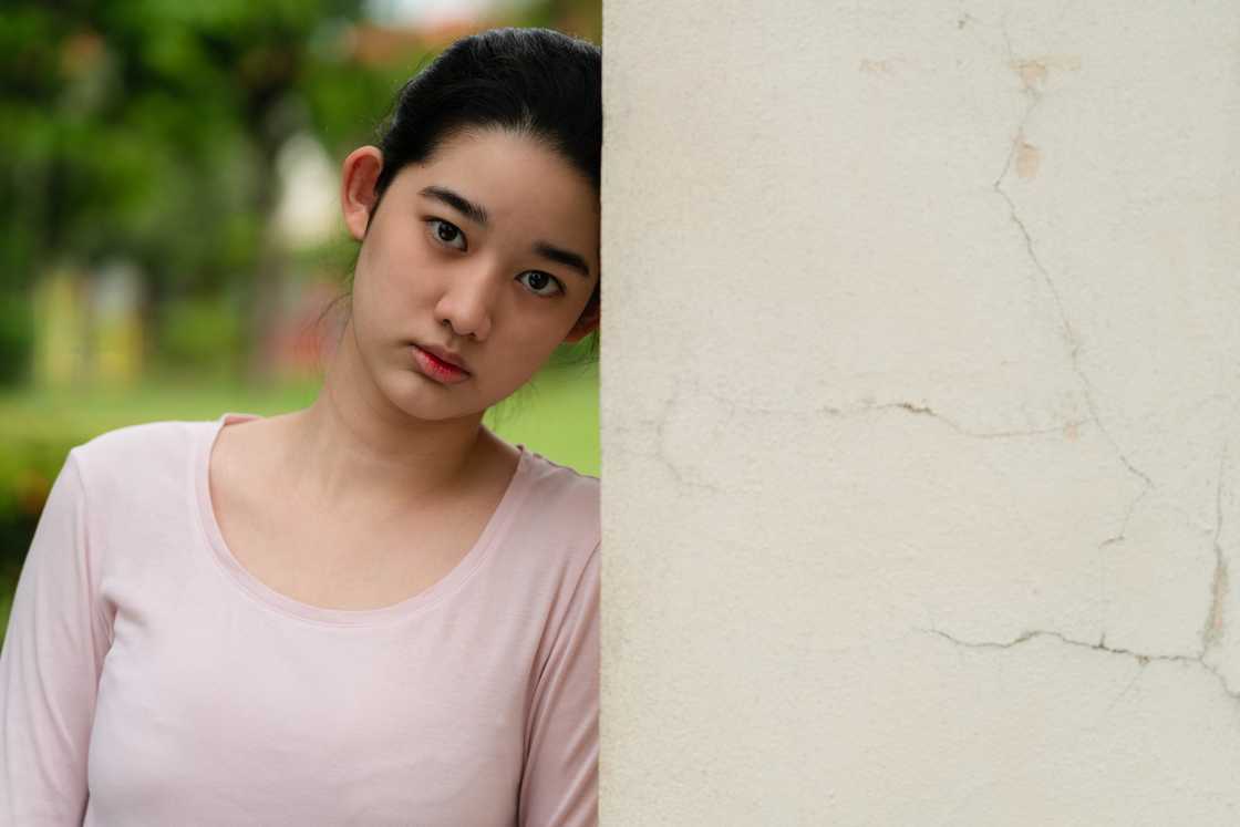 A sad girl standing and looking at the camera A sad girl standing and looking at the camera