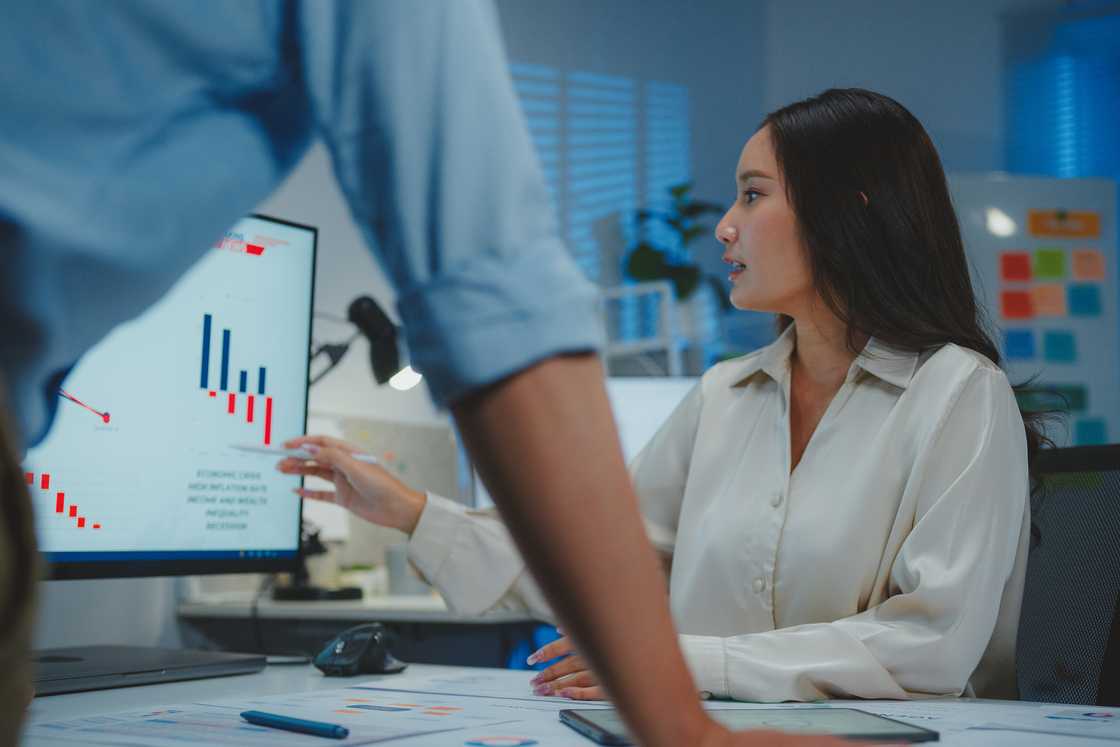 A lady show a man data on a computer