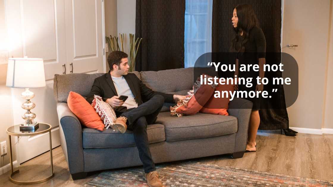 A couple have a tense conversation indoors at night.