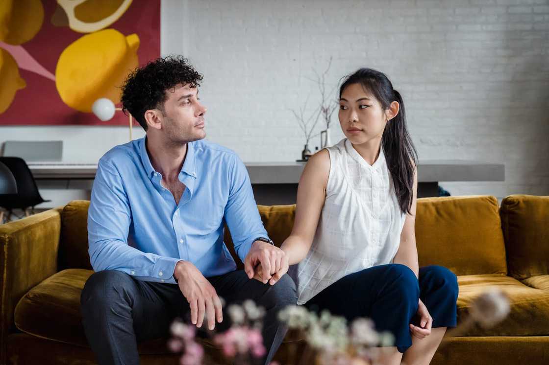 A moment of emotional distance as a couple sits together. A moment of emotional distance as a couple sits together.