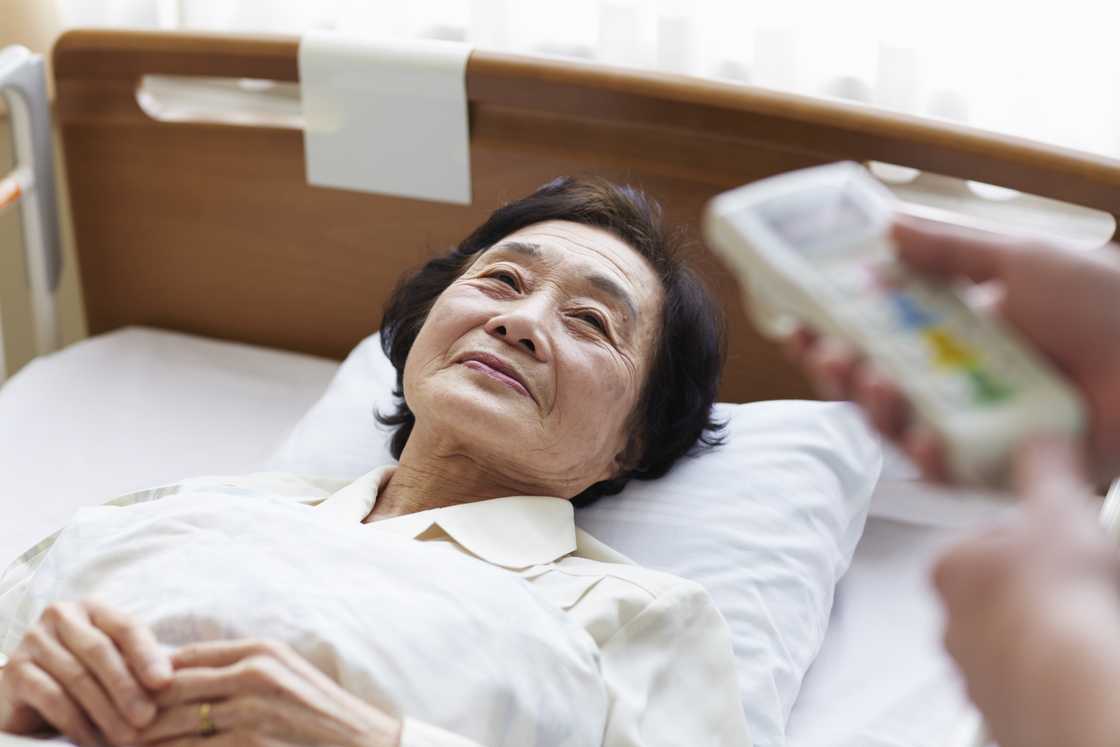 A man lying in a hospital bed smiling