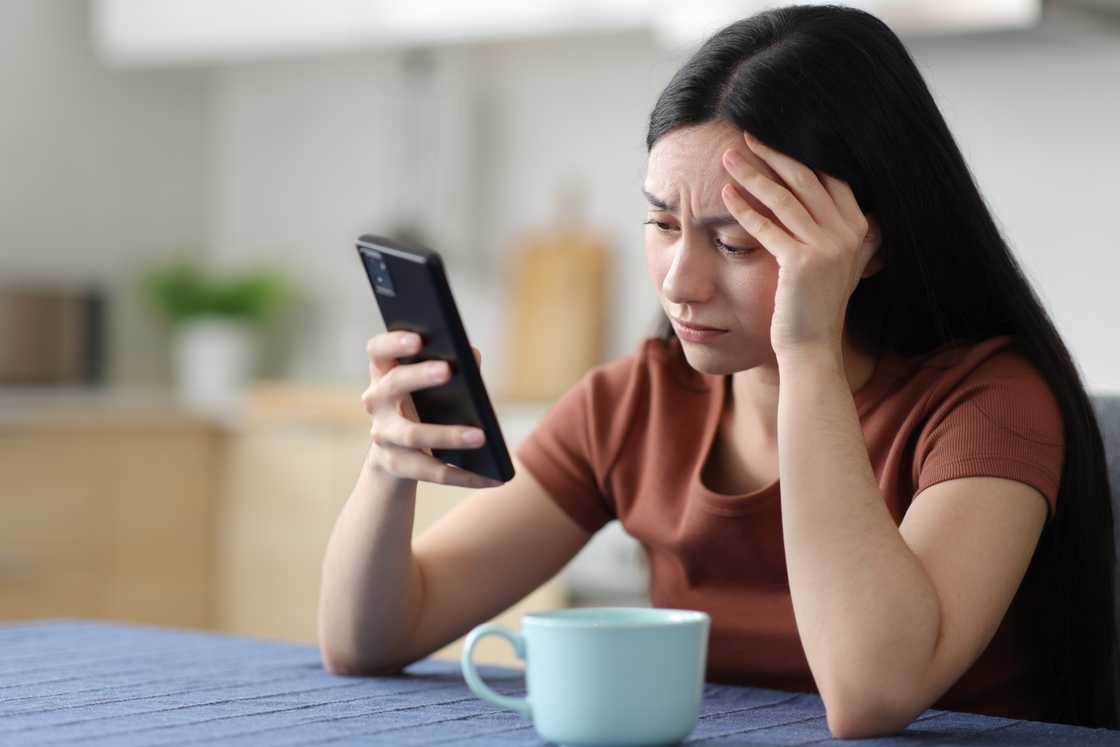 A sad woman looking at her phone A sad woman looking at her phone