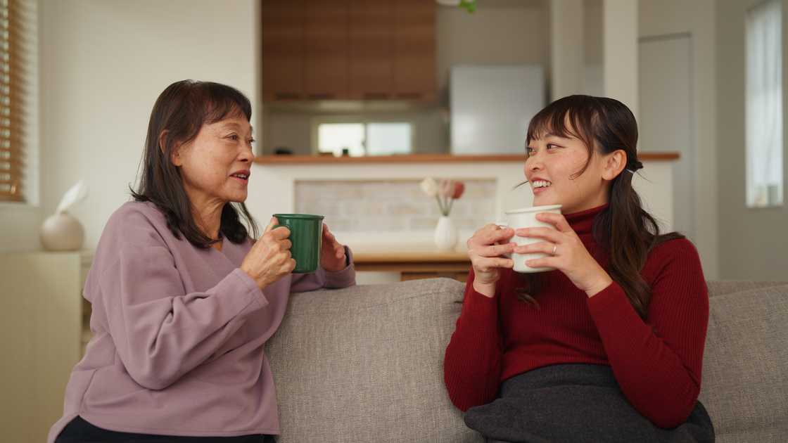 A mother and adult daughter having tea