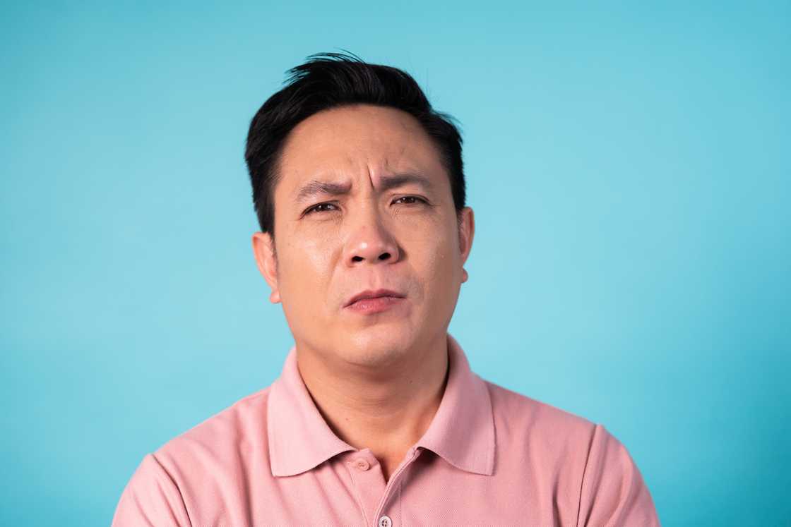 A middle-aged man looking forward with a frown. A middle-aged man looking forward with a frown.