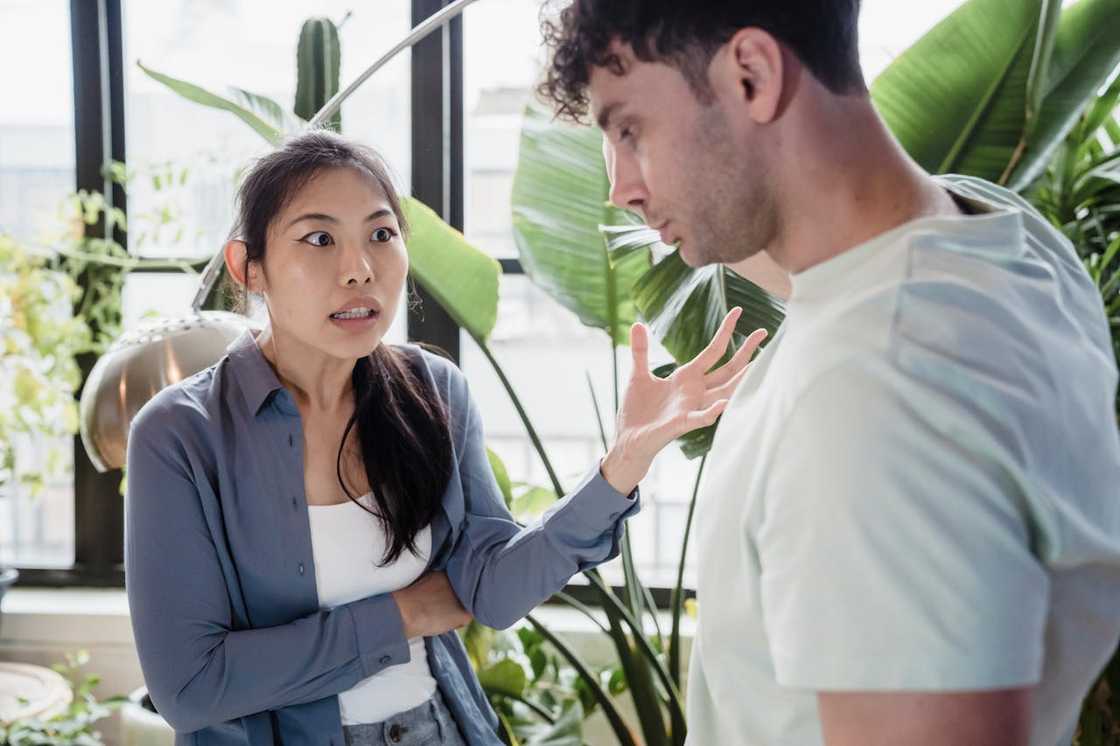 A woman argues with a man in a bright indoor space. A woman argues with a man in a bright indoor space.