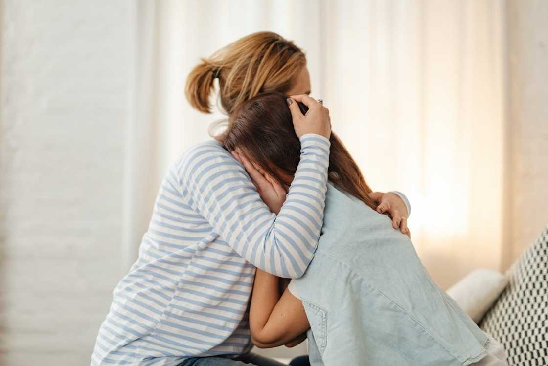 A mother and daughter embrace each other in an emotional moment. A mother and daughter embrace each other in an emotional moment.