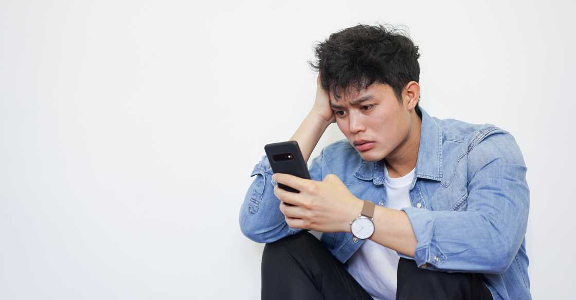 A worried man using his phone