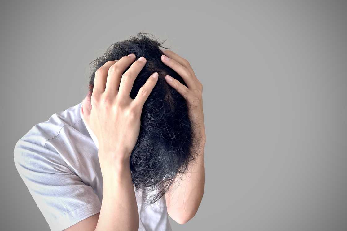 A stressed man holds his head A stressed man holds his head