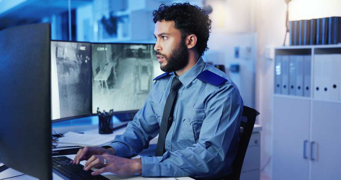 An officer sitting in front of computer monitor and looking at screen An officer sitting in front of computer monitor and looking at screen