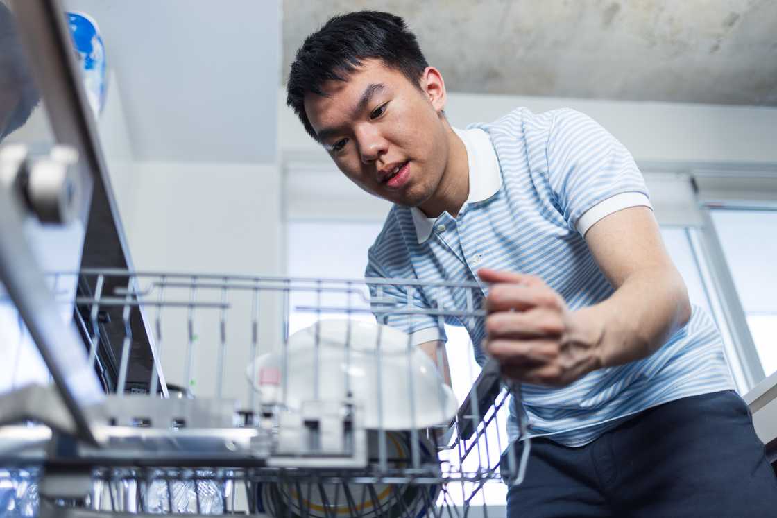 A man is doing dishes in the kitchen A man is doing dishes in the kitchen