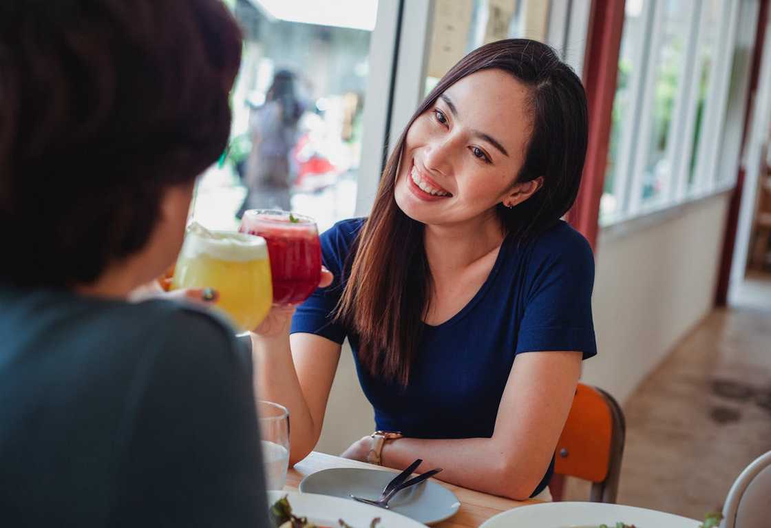 A couple sits by a window in a cafe, quietly enjoying drinks. A couple sits by a window in a cafe, quietly enjoying drinks.
