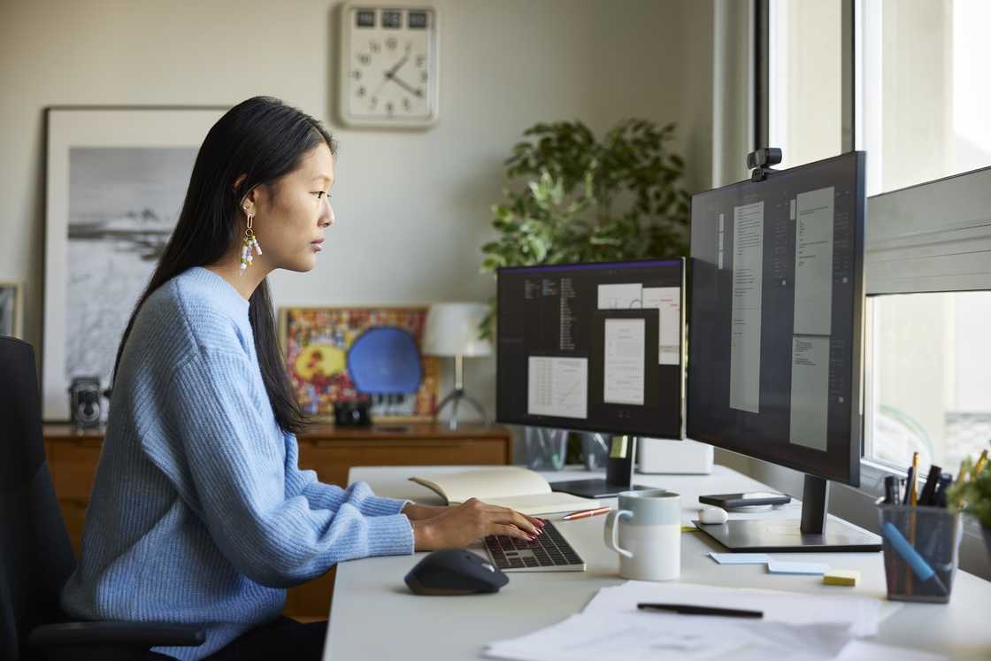 A woman is scrolling on a computer
