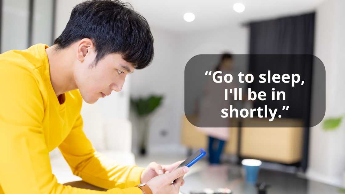 A man chatting while talking to his wife in the background A man chatting while talking to his wife in the background