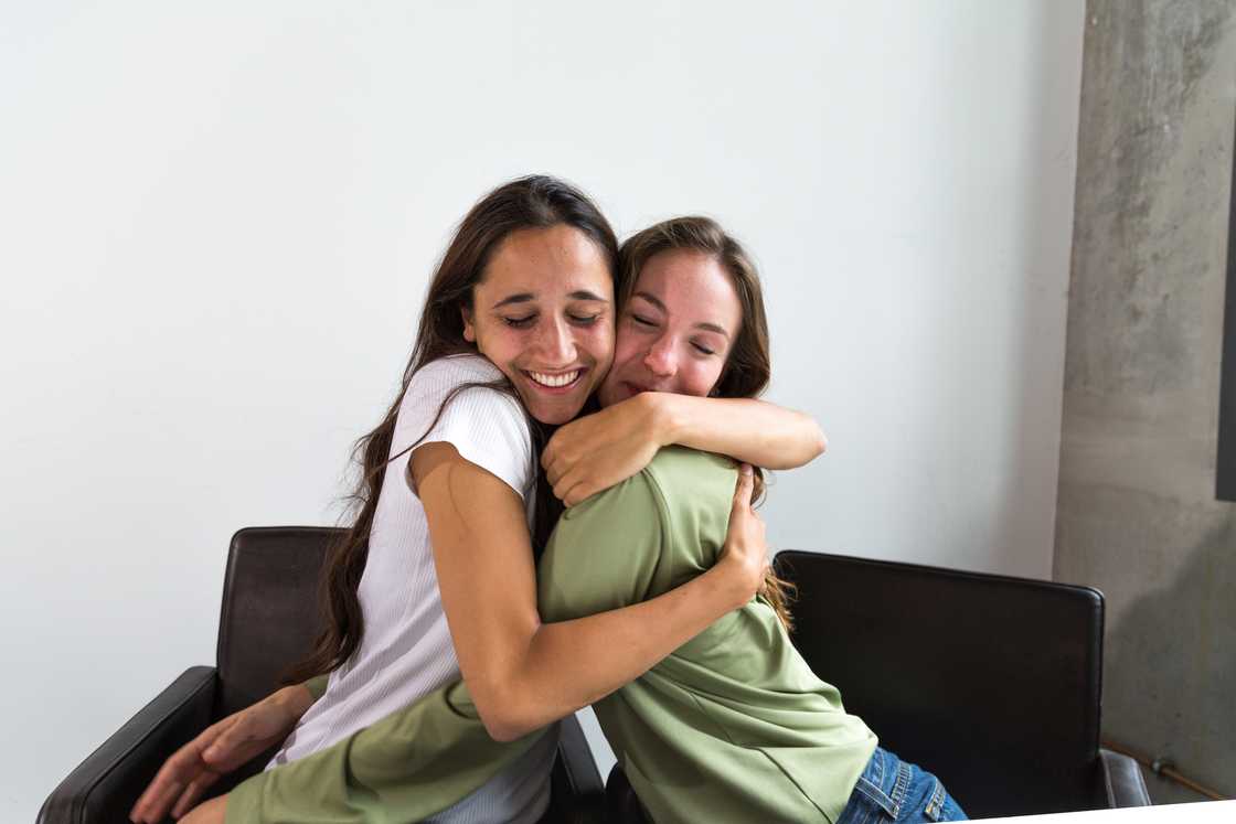 Two ladies are hugging