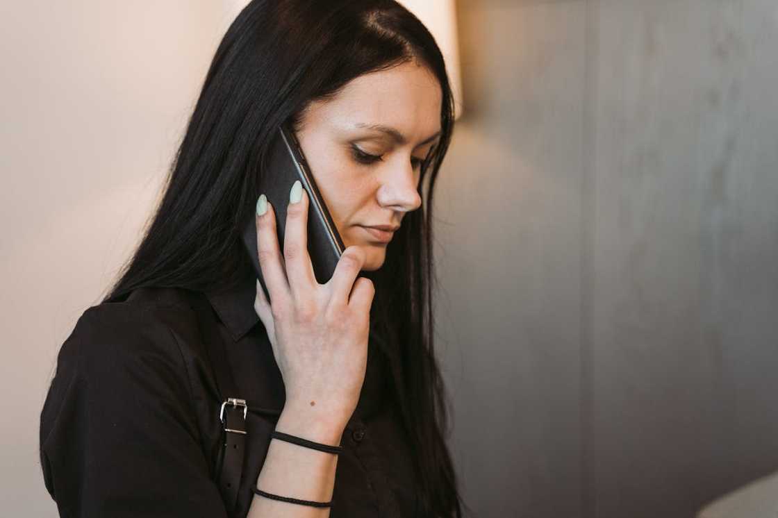 Close-up of a woman speaking on a phone indoors.