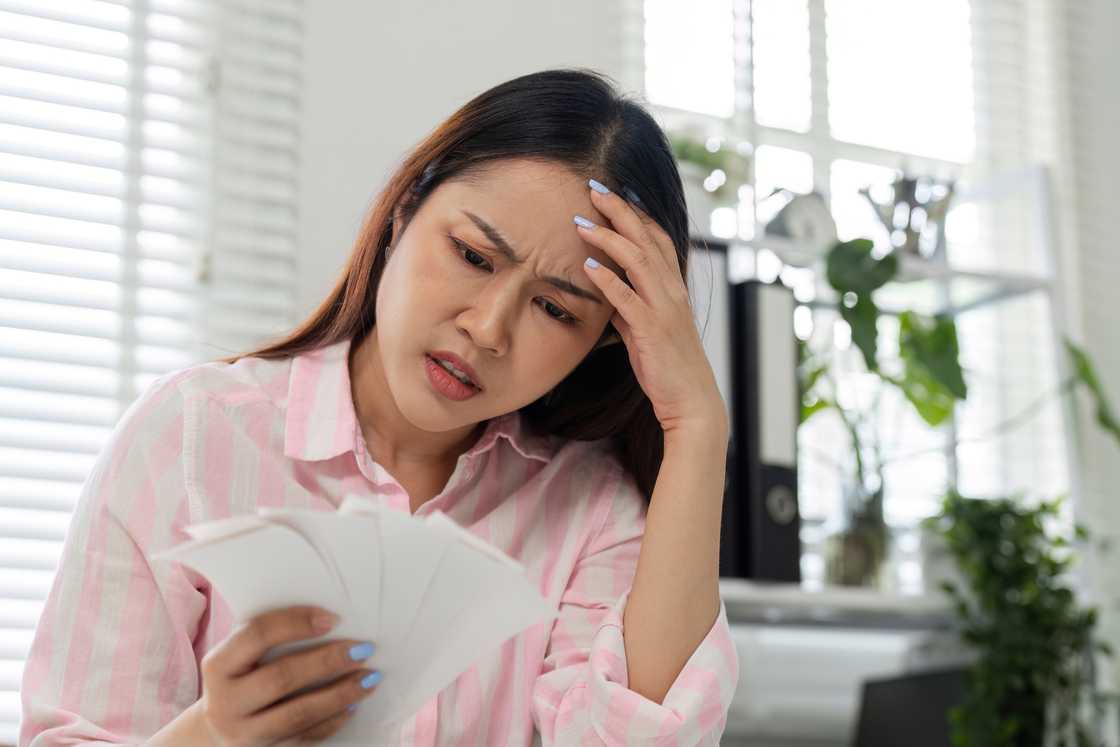 A disappointed woman staring at documents in her hands