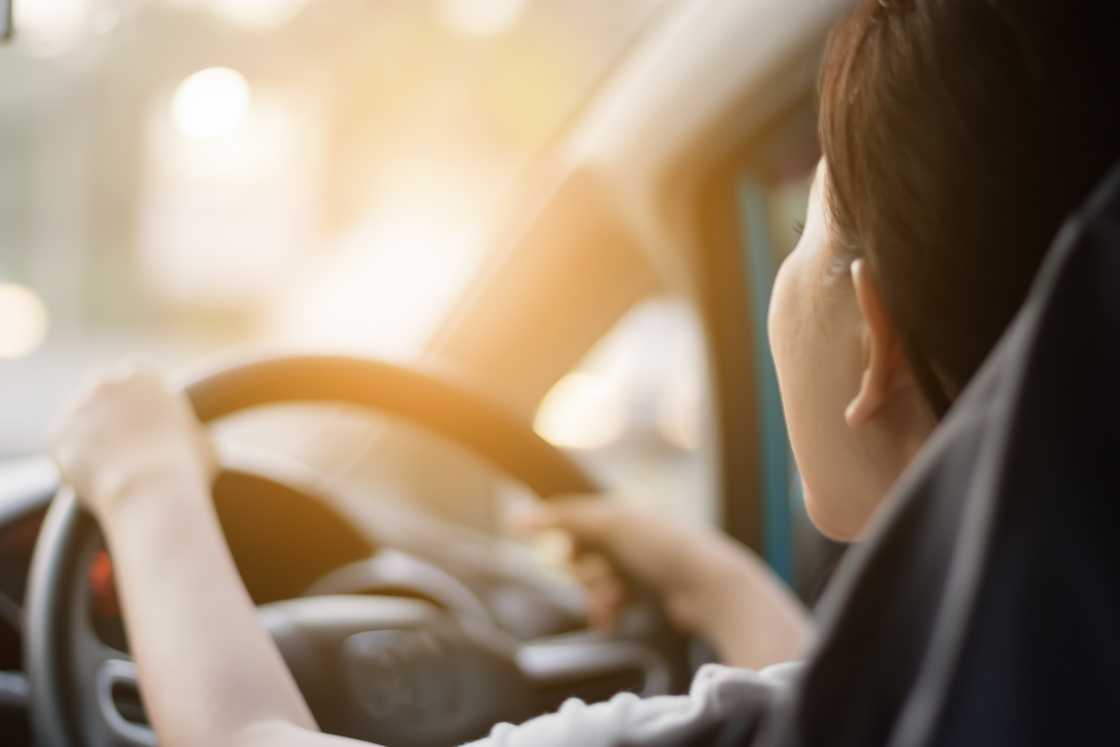 A lady is driving a car