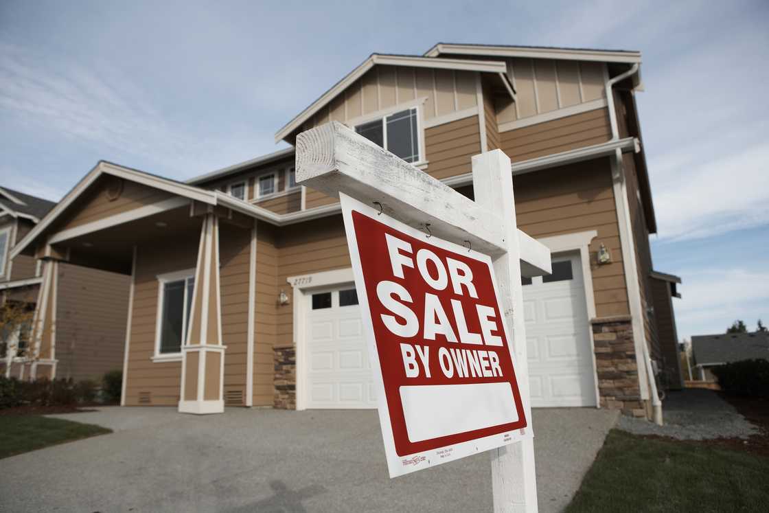 A suburban house with "For Sale By Owner" sign A suburban house with "For Sale By Owner" sign