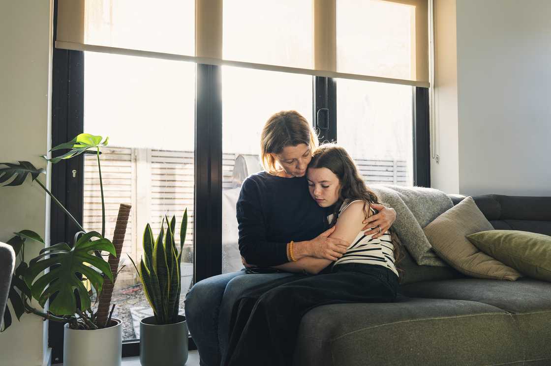 A worried woman comforting a teen girl A worried woman comforting a teen girl
