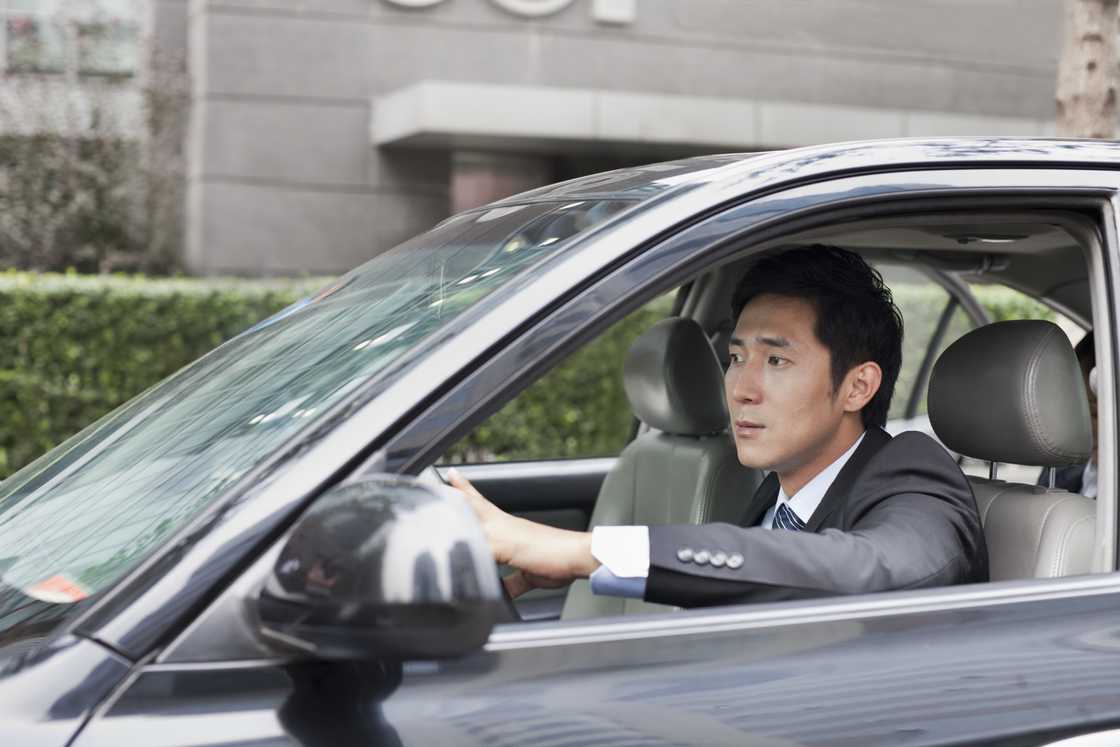 A serious businessman is driving