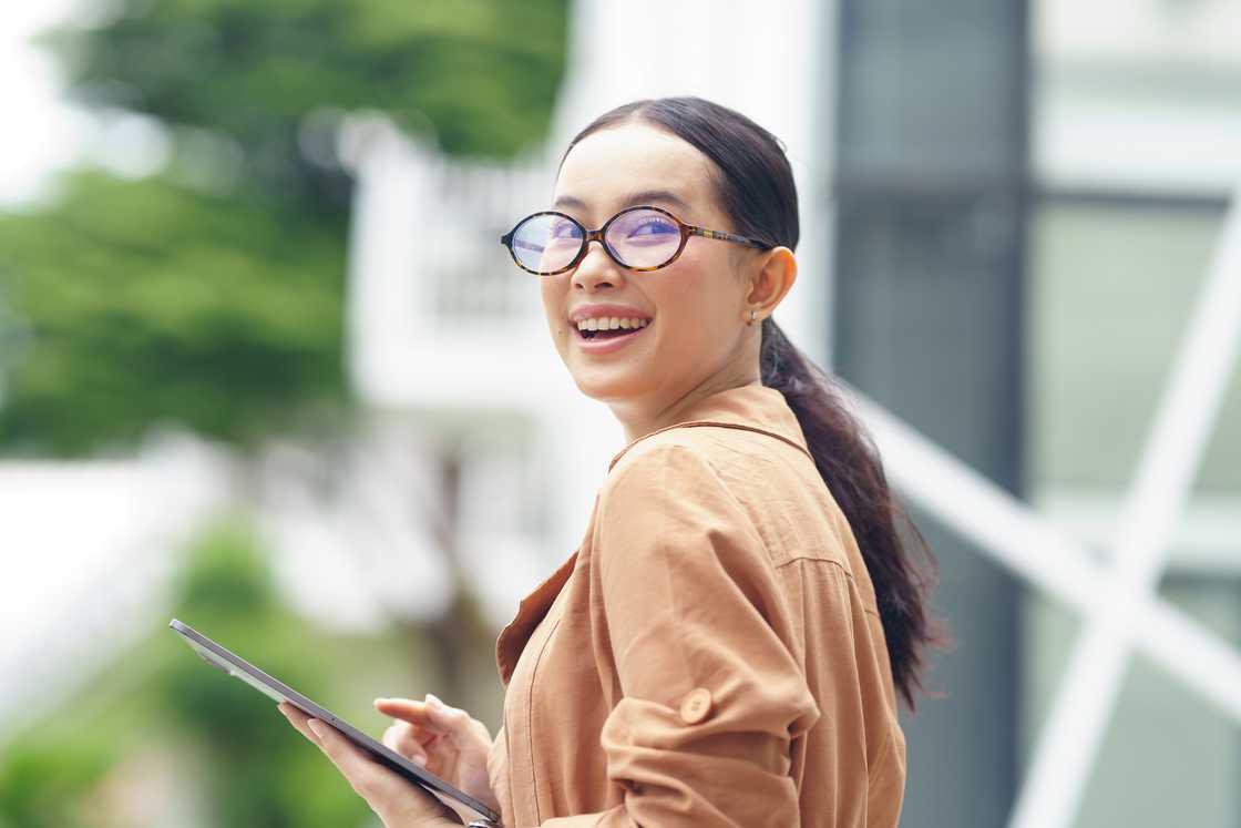 A young woman walking while using a laptop A young woman walking while using a laptop