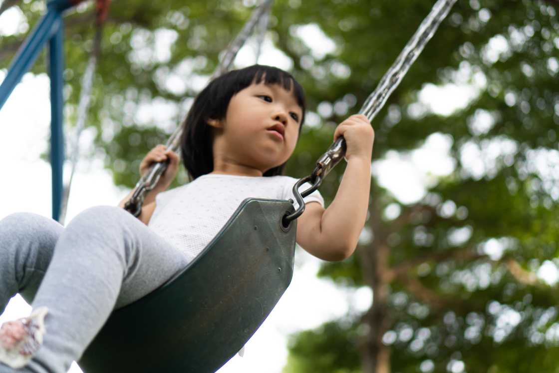 A young girl swinging at the park