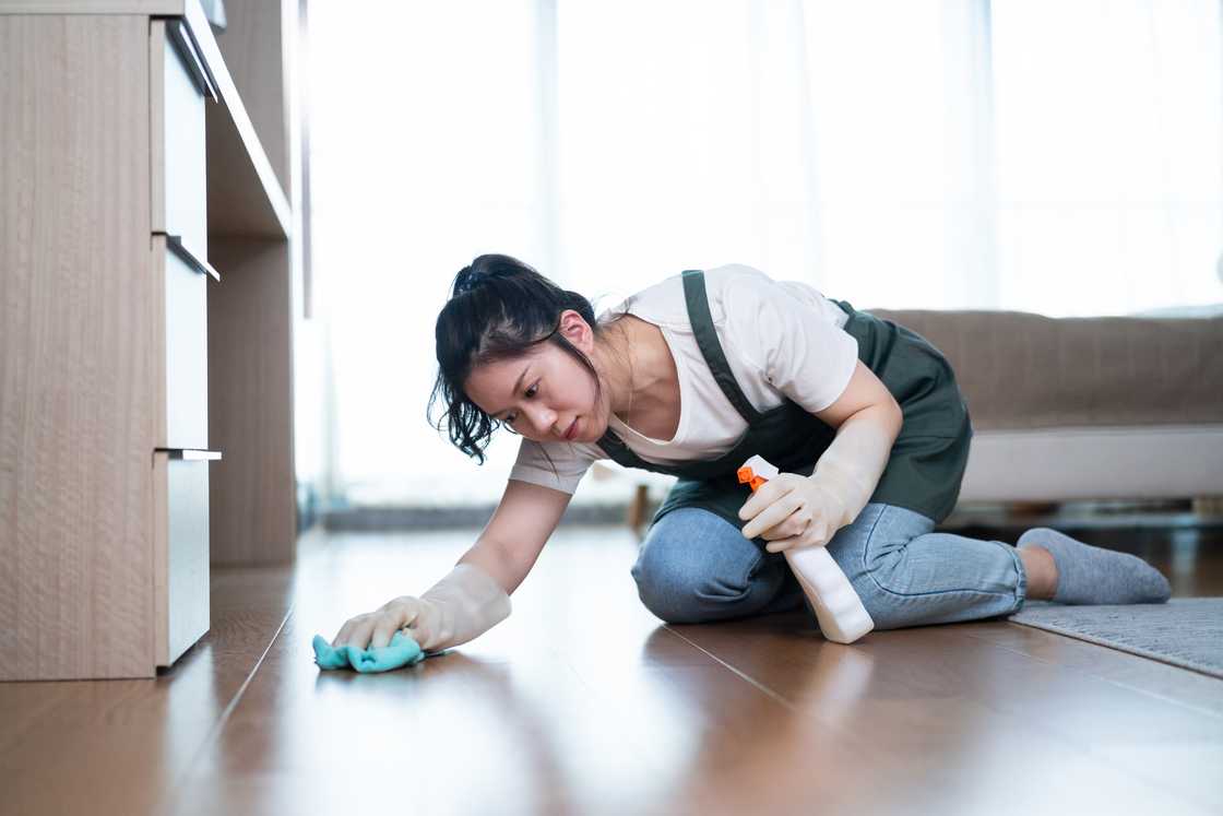 A woman cleaning the floor at home