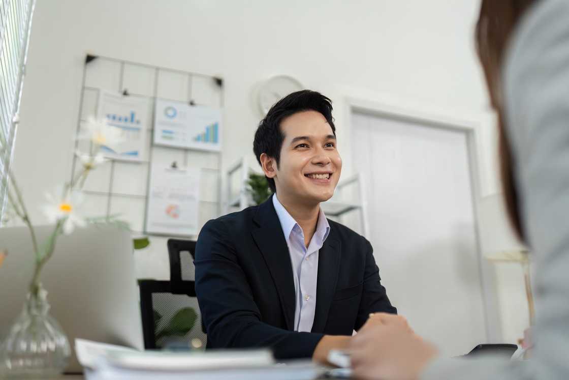 A business consultant smiling and engaging in conversation with a client A business consultant smiling and engaging in conversation with a client