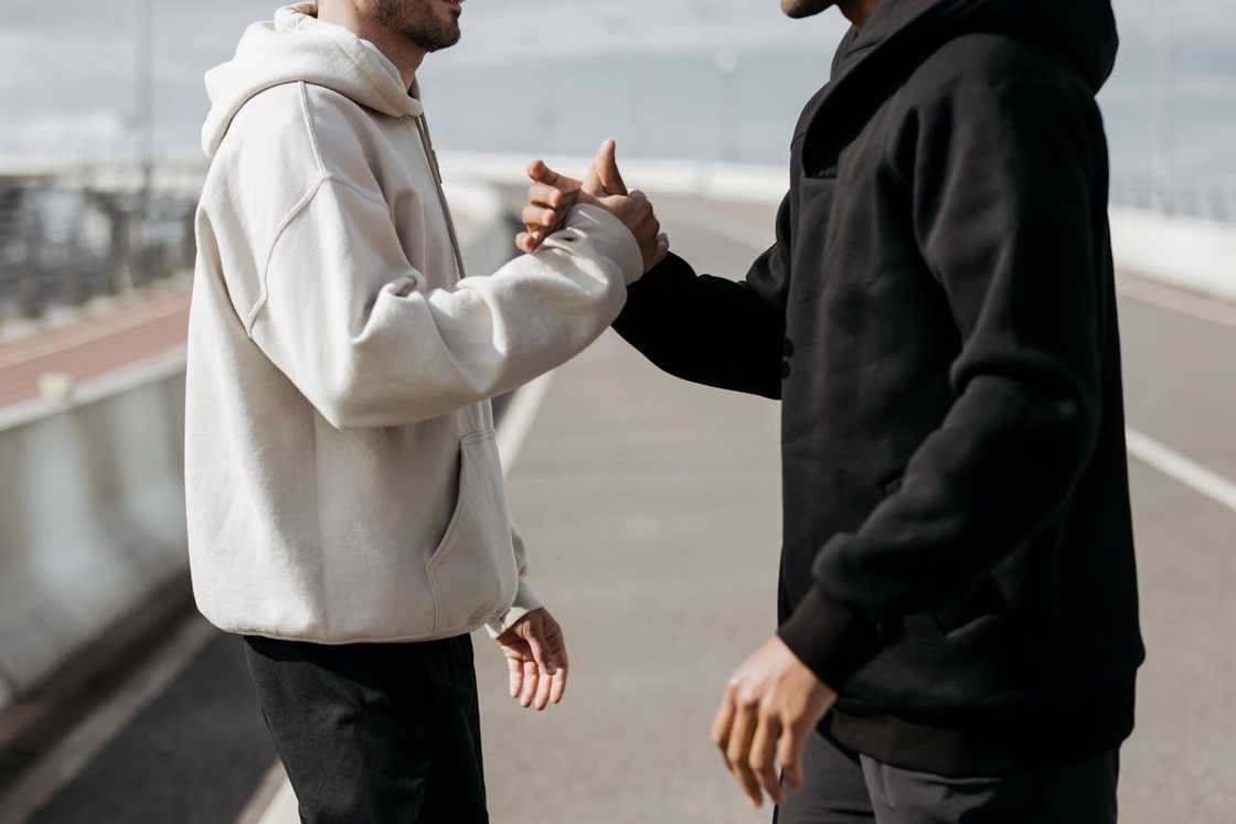 Two men greeting each other with a handshake outdoors. Two men greeting each other with a handshake outdoors.