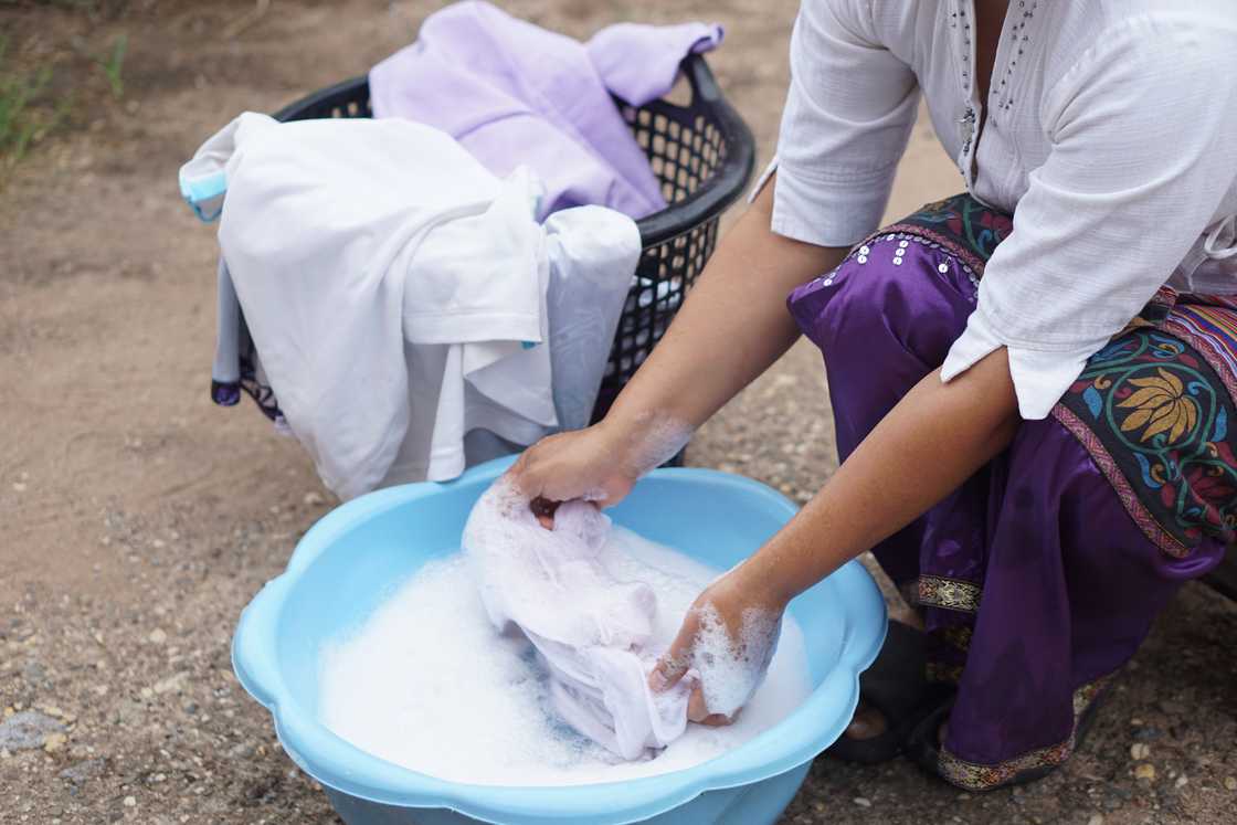 A lady handwashing clothes A lady handwashing clothes