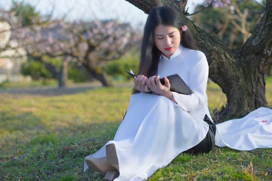 A woman journaling outdoors. A woman journaling outdoors.