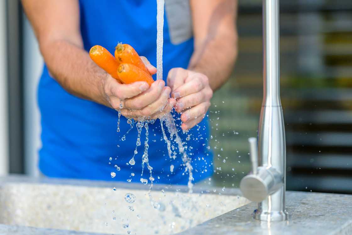 Man washing vegetables grown in his garden