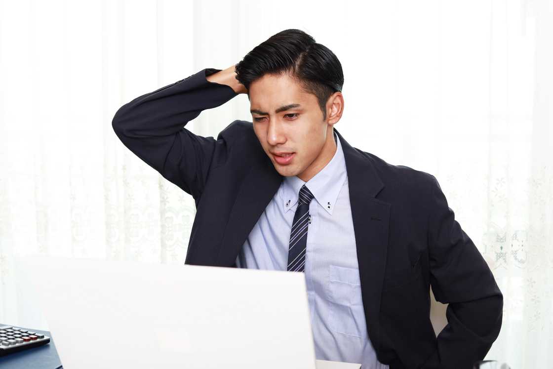 A stressed man looking at a laptop. A stressed man looking at a laptop.