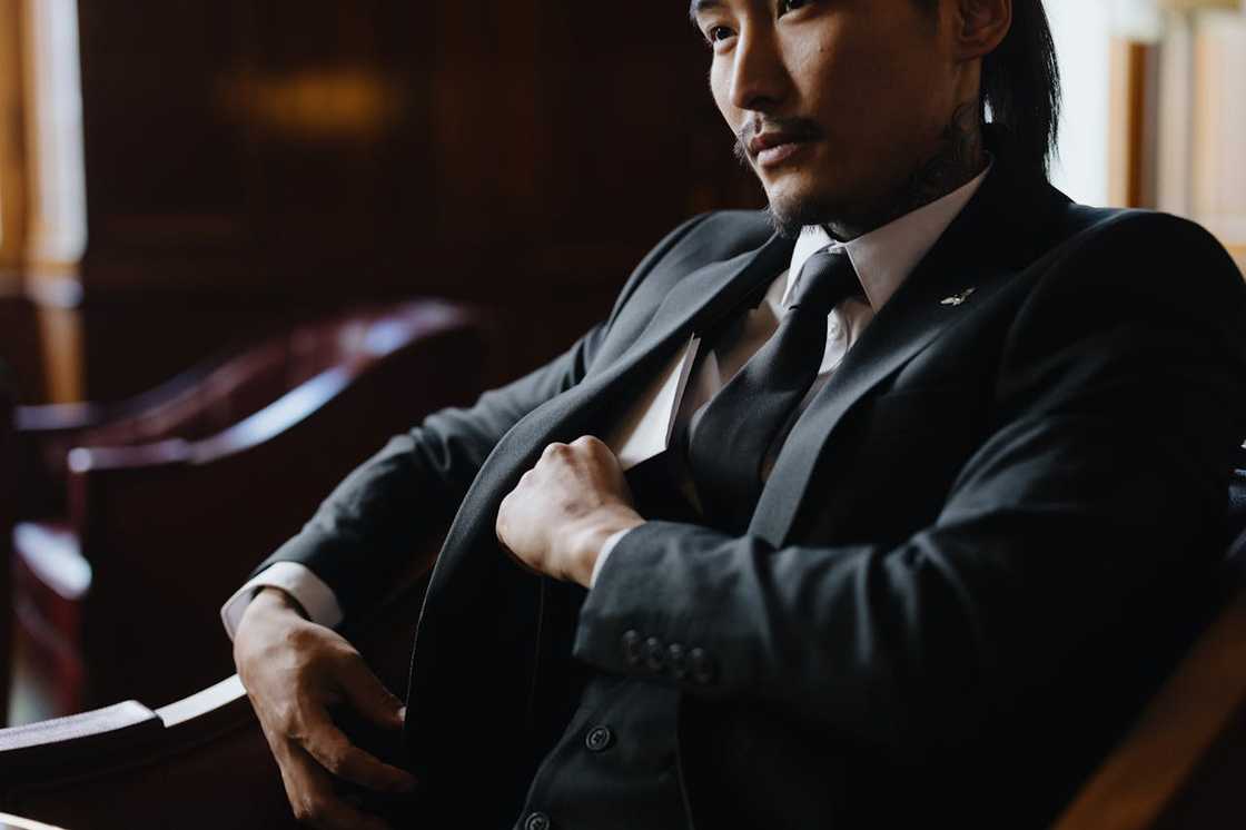 A hidden camera catches a man reaching into his pocket for a concealed folder.