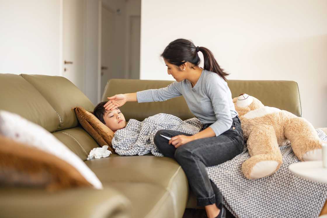 A mother taking care of sick child at home
