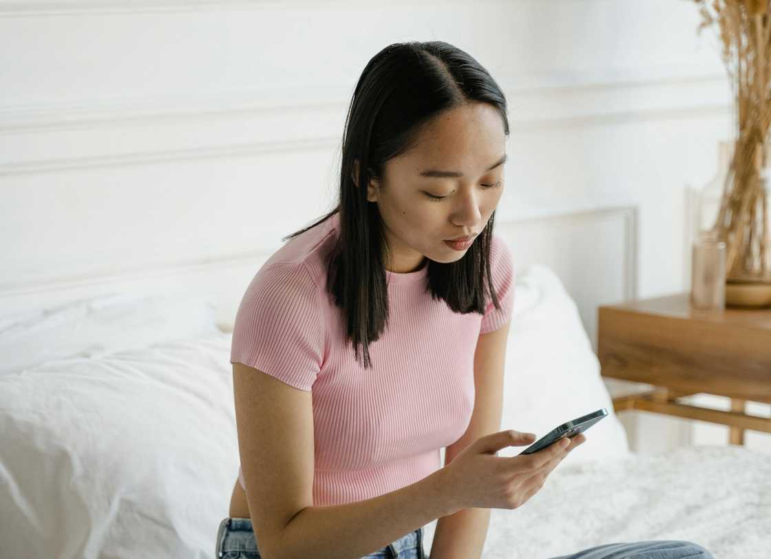 A sad woman reading a message on her phone A sad woman reading a message on her phone