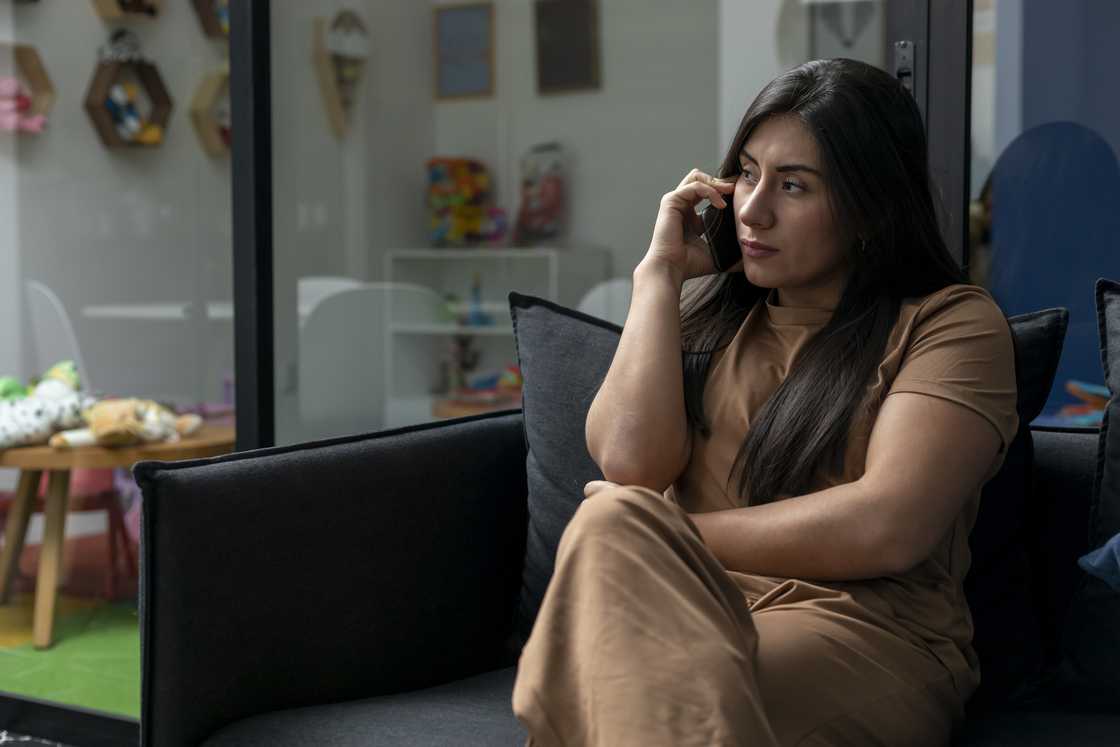 A sad woman on a call in a hospital waiting room A sad woman on a call in a hospital waiting room