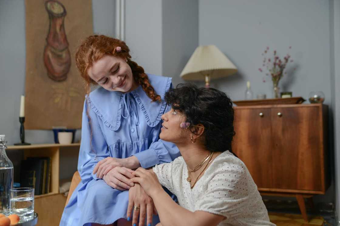 Two women sit close together, sharing a quiet, supportive moment. Two women sit close together, sharing a quiet, supportive moment.