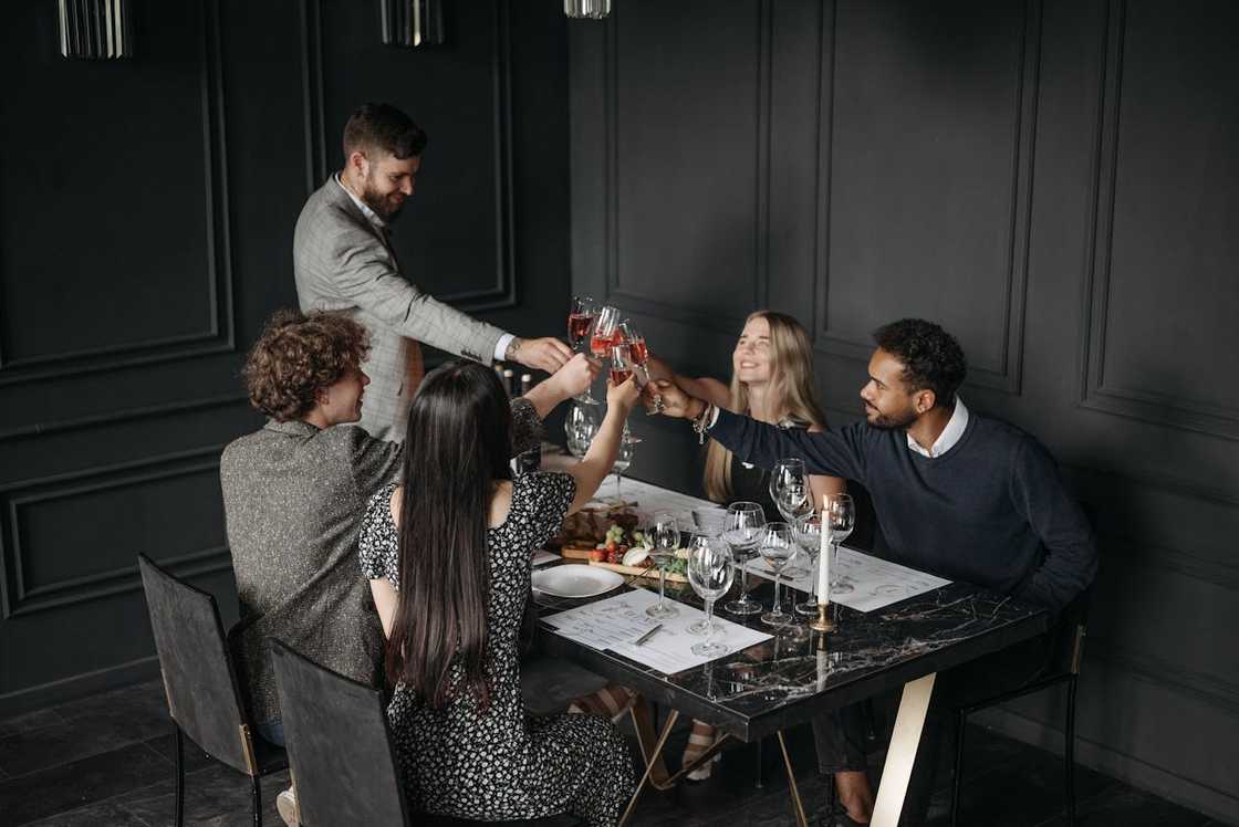 A family share a meal at a sunlit dining table. A family share a meal at a sunlit dining table.