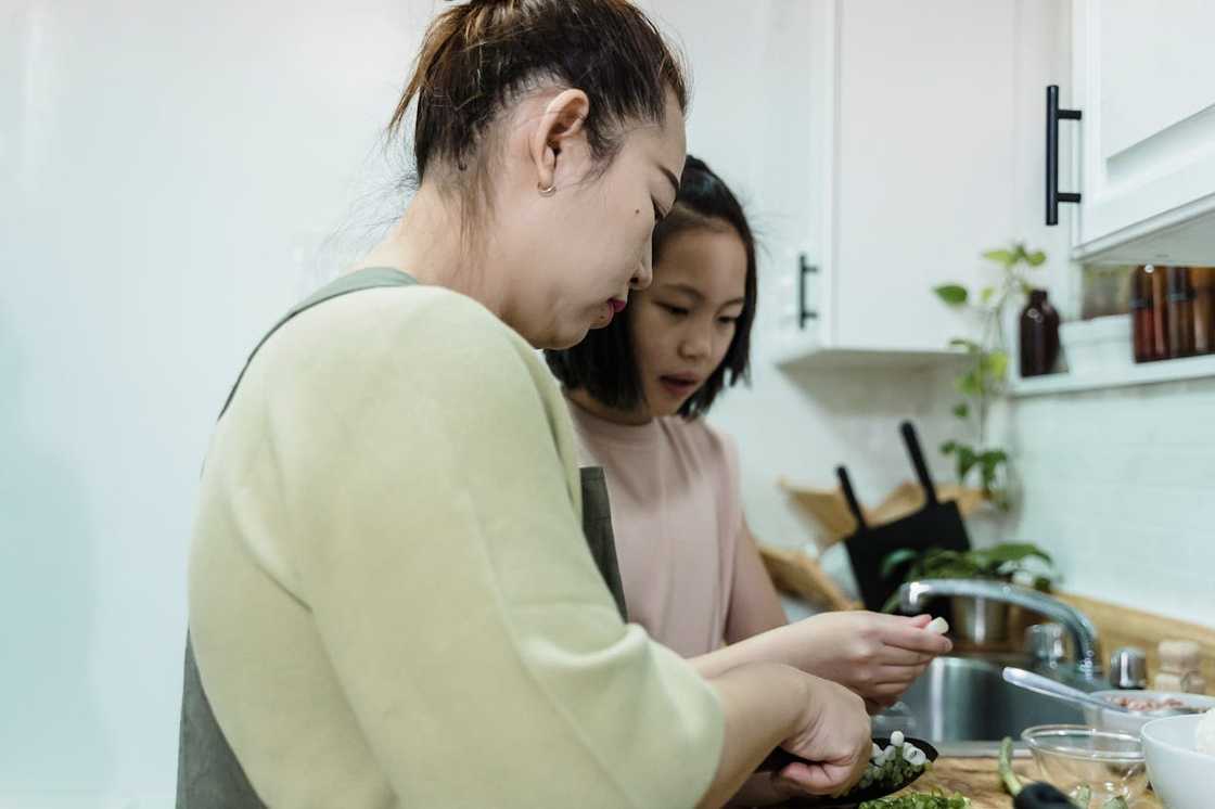 Mom and daughter have fun cooking in the kitchen.