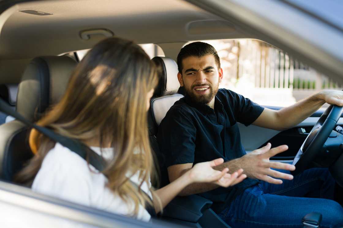 A man fighting with his girlfriend inside a car