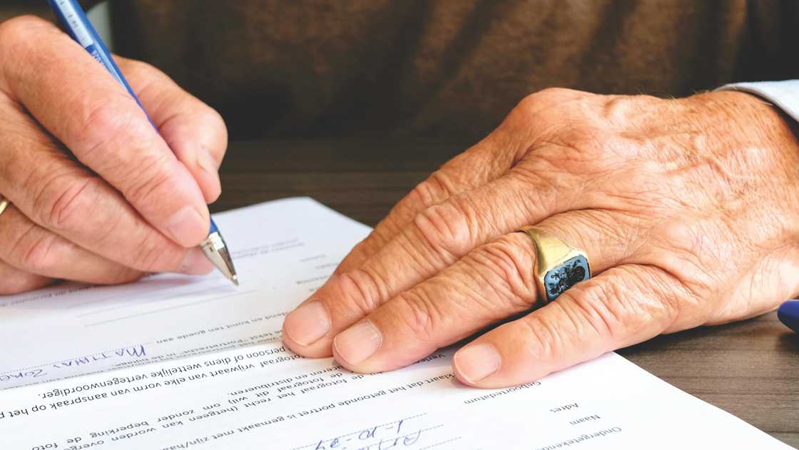 A mature man signing documents