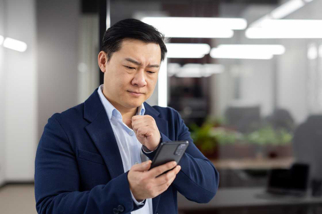 A man in disbelief after seeing CCTV footage on a phone A man in disbelief after seeing CCTV footage on a phone