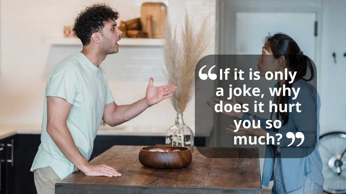 A couple arguing in a kitchen while gesturing. A couple arguing in a kitchen while gesturing.