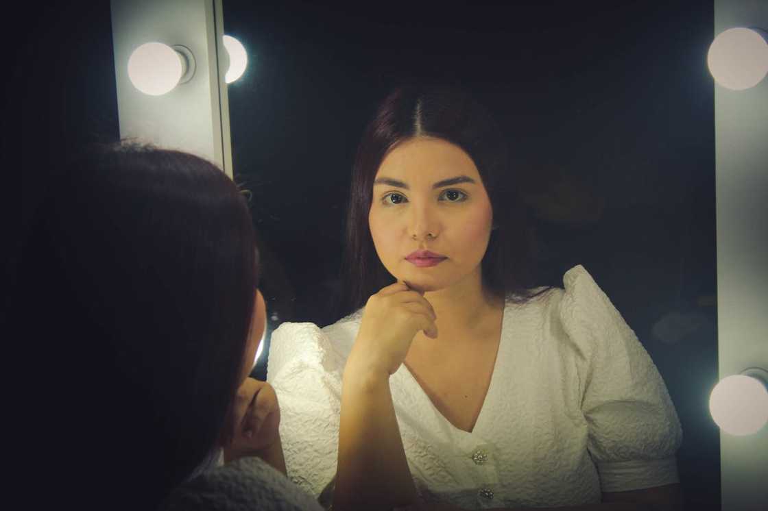 A woman looks at herself in the mirror. A woman looks at herself in the mirror.