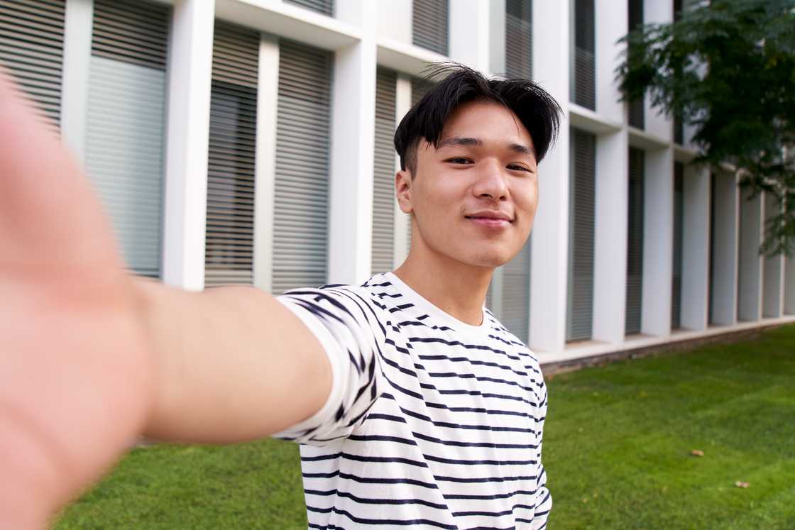 A cheerful Asian man is taking a selfie