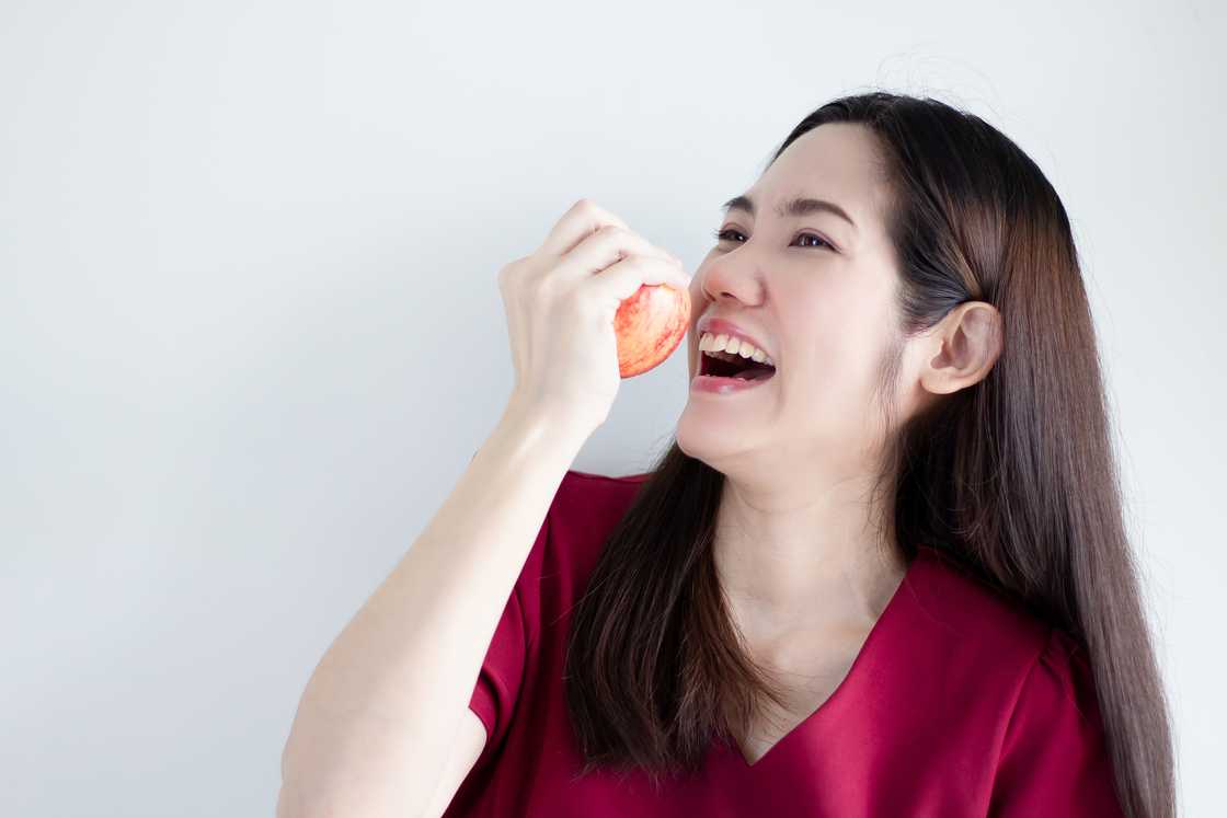 A woman biting an apple A woman biting an apple