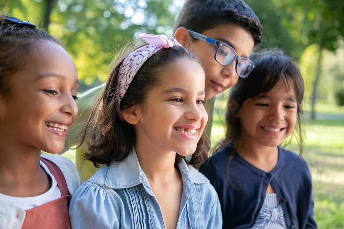 Group of smiling children standing together outdoors in a park. Group of smiling children standing together outdoors in a park.
