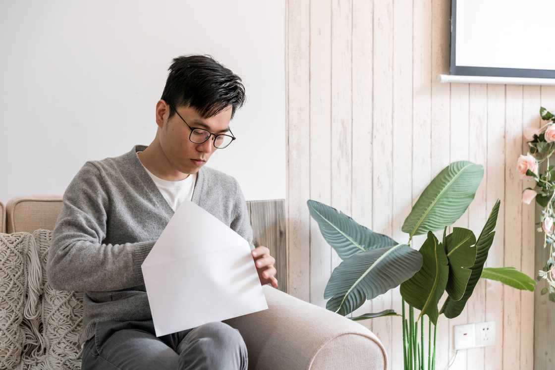 tense man opening an envelope tense man opening an envelope
