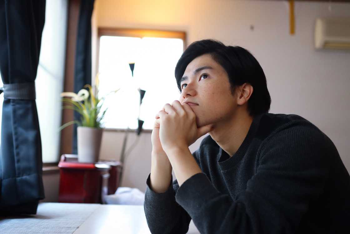 A young man thinking about something inside of room